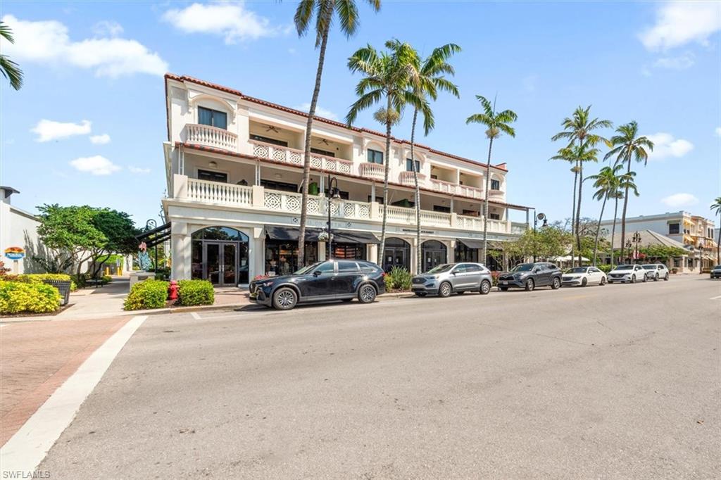 a front view of a building with palm trees