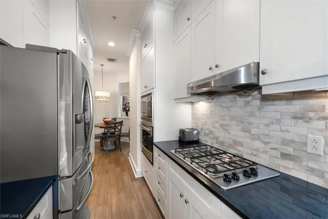 a kitchen with wooden floor and a stove top oven
