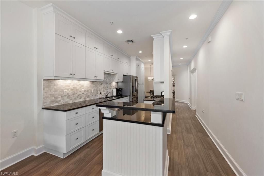 555 5th Avenue South, Unit 204 Naples, FL 34102 - Photo 13 of 30 a kitchen with granite countertop a sink appliances cabinets and wooden floor
