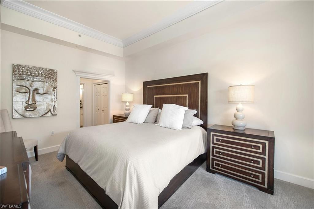 555 5th Avenue South, Unit 204 Naples, FL 34102 - Photo 18 of 30 a bedroom with a bed and a night stand