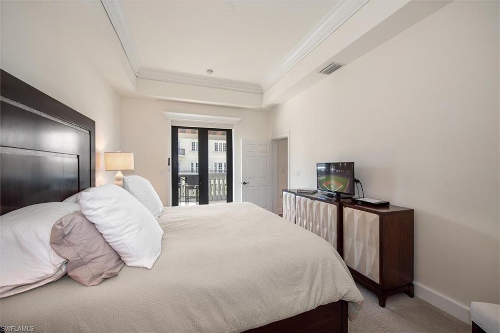 555 5th Avenue South, Unit 204 Naples, FL 34102 - Photo 19 of 30 a bedroom with a bed and a tv on table