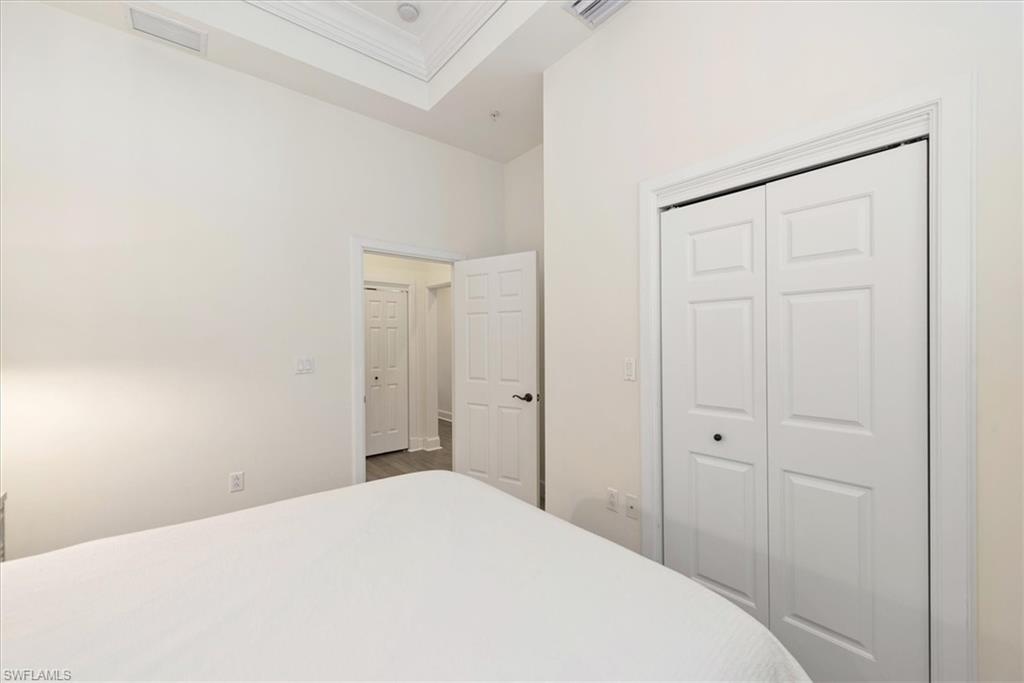 555 5th Avenue South, Unit 204 Naples, FL 34102 - Photo 23 of 30 a bedroom with a bed and a closet