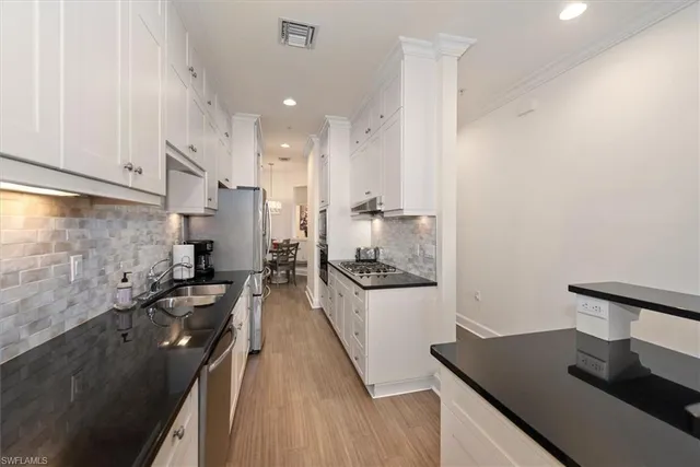 a kitchen with granite countertop a sink stove and cabinets