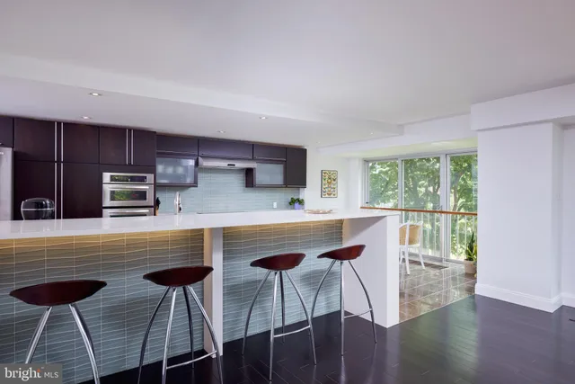 a kitchen with stainless steel appliances granite countertop a stove a sink a microwave and wooden cabinets