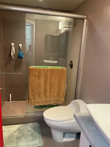 a bathroom with a granite countertop bathtub shower sink and toilet