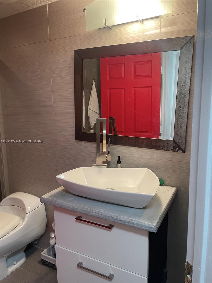 2541 Centergate Drive, Unit 205 Miramar, FL 33025 - Photo 12 of 28 a bathroom with a sink a toilet and mirror