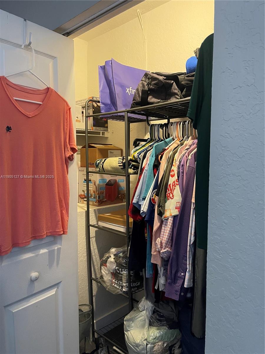 2541 Centergate Drive, Unit 205 Miramar, FL 33025 - Photo 10 of 28 a view of walk in closet with clothes and shoes