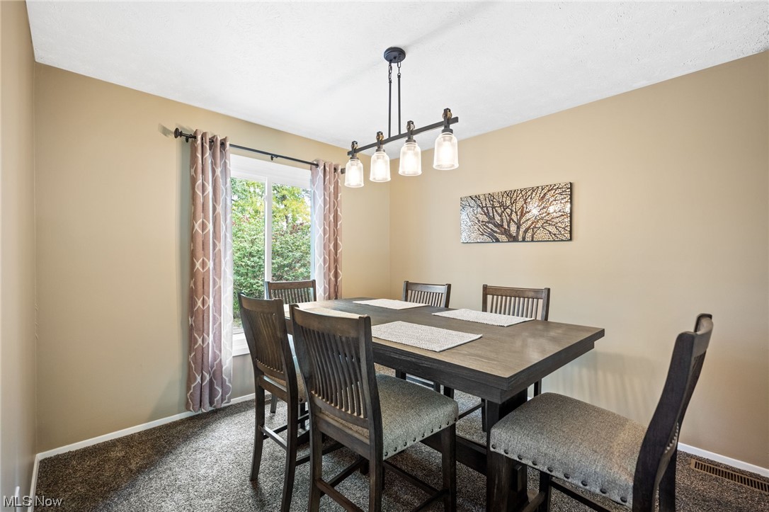 10798 Gate Post Road Strongsville, OH 44149 - Photo 11 of 32 Carpeted dining space with a notable chandelier