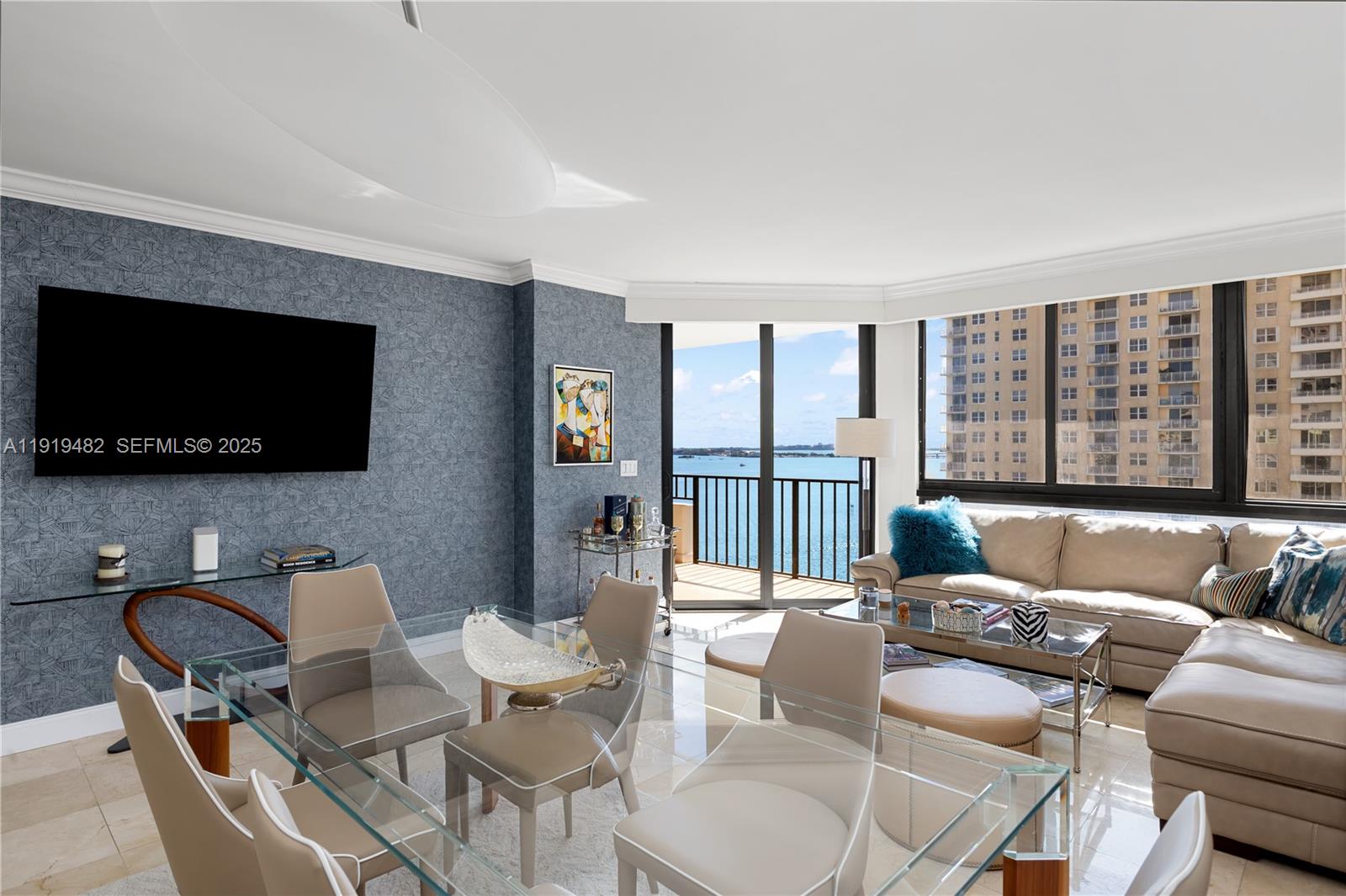 520 Brickell Key Drive, Unit A1207 Miami, FL 33131 - Photo 6 of 33 a living room with furniture a flat screen tv and a floor to ceiling window