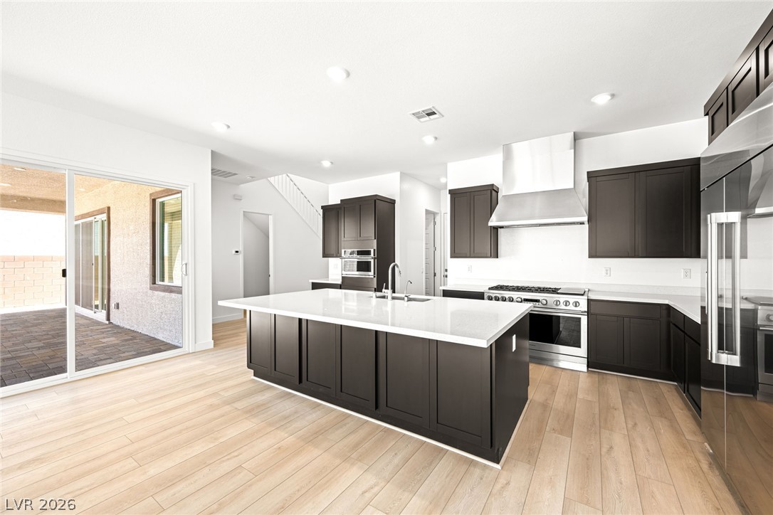 9983 Decano Ridge Street Las Vegas, NV 89141 - Photo 15 of 39 Modern kitchen with an inviting island and light wood flooring opens to an outdoor patio.
