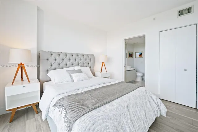 a bedroom with a bed and wooden floor