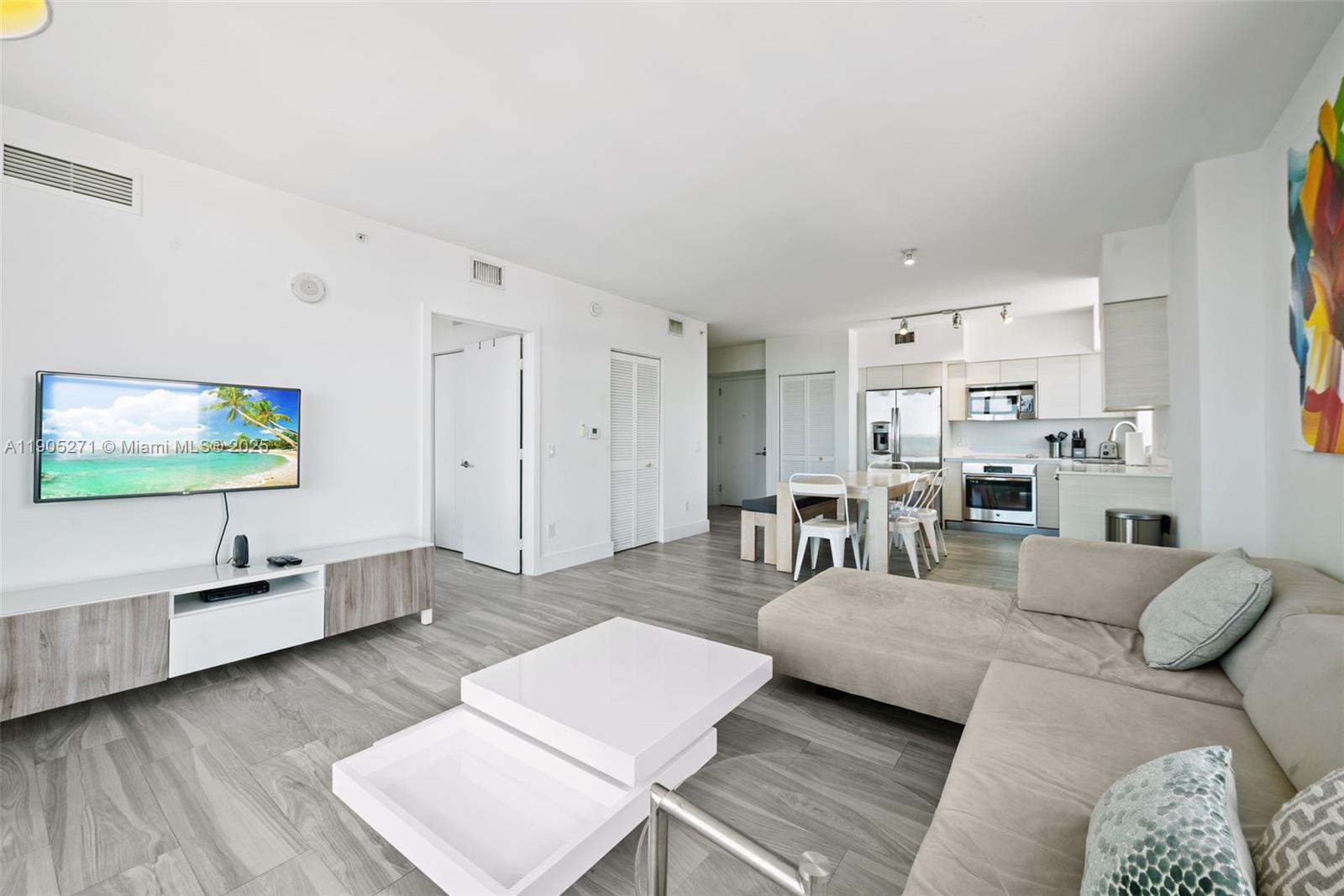 4250 Biscayne Boulevard, Unit 1009 Miami, FL 33137 - Photo 3 of 23 a living room with furniture and a flat screen tv