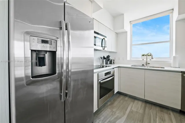a kitchen with stainless steel appliances granite countertop a refrigerator and a sink