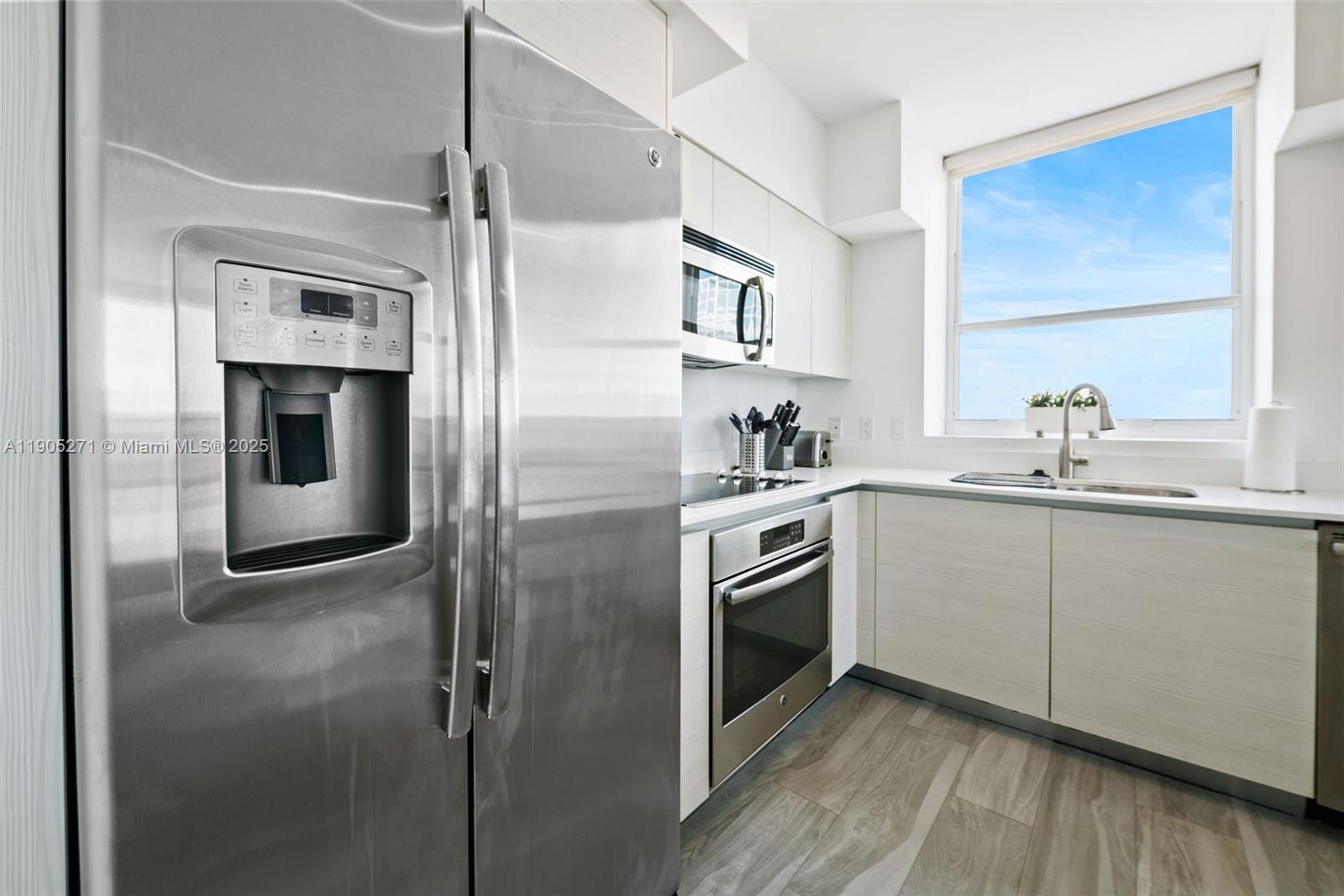 4250 Biscayne Boulevard, Unit 1009 Miami, FL 33137 - Photo 4 of 23 a kitchen with stainless steel appliances granite countertop a refrigerator and a sink