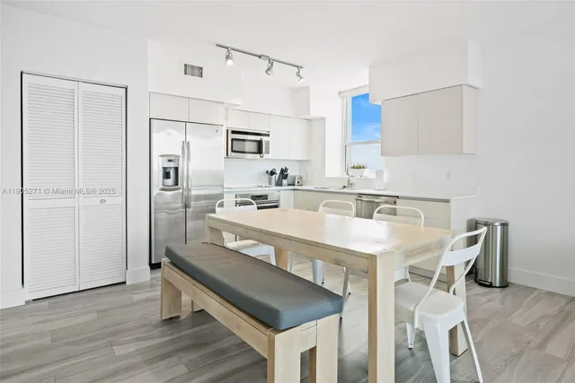 a kitchen with stainless steel appliances granite countertop a sink a stove and a refrigerator