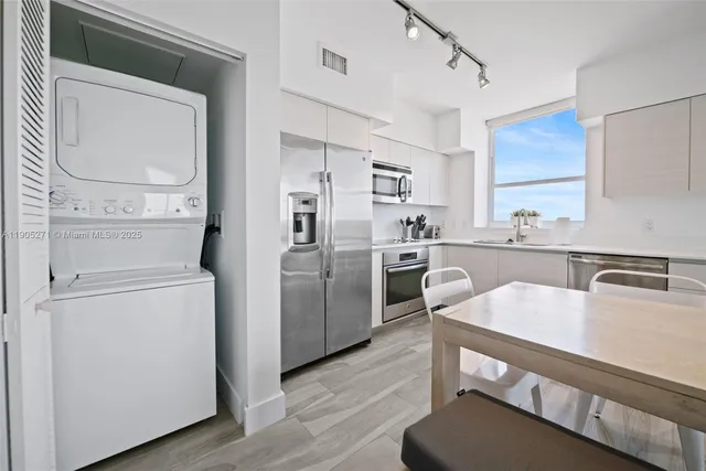 a kitchen with white cabinets and stainless steel appliances