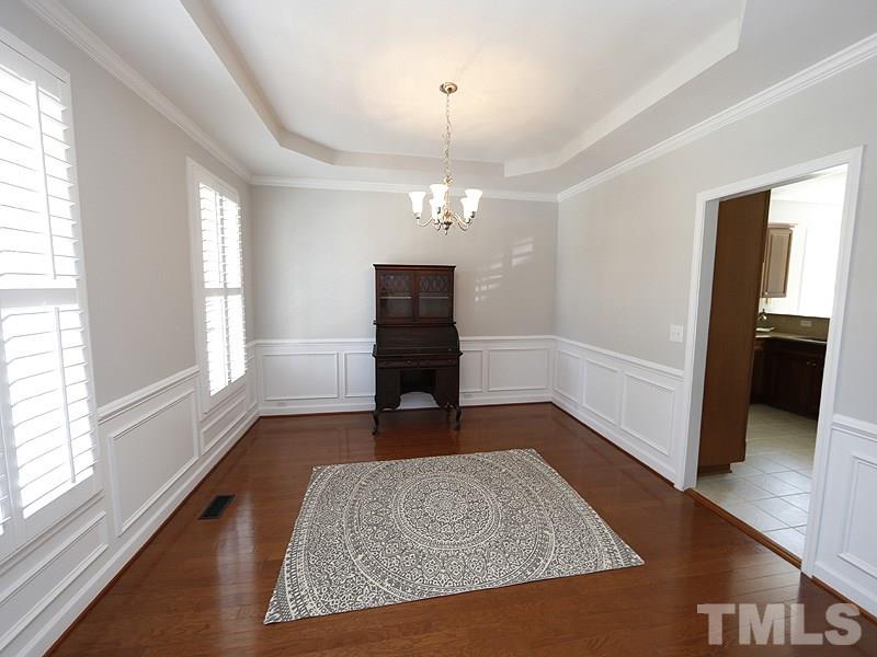 3324 Queensland Road Raleigh, NC 27614 - Photo 4 of 25 The dining room with tray ceiling and wainscoting sits to the left of the foyer. Hardwoods grace most of the first floor.