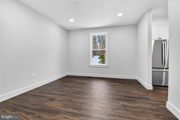 a view of a hallway with wooden floor and stairs