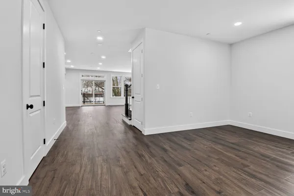 a view of a big room with wooden floor and windows