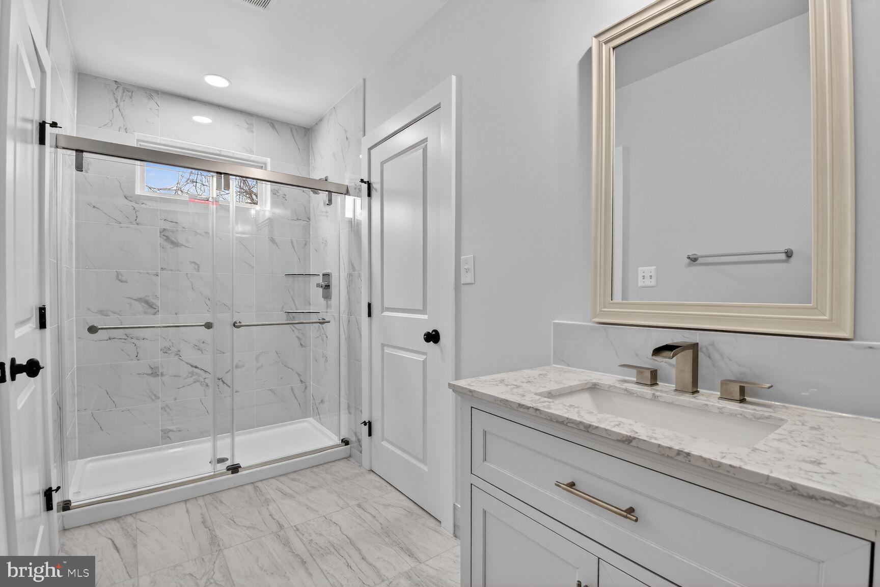 13102 Ideal Drive Silver Spring, MD 20906 - Photo 33 of 48 a bathroom with a granite countertop sink mirror and shower