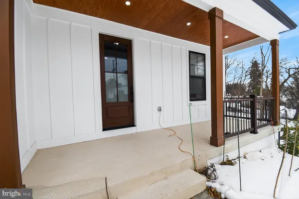 a front view of a house with a yard covered with snow
