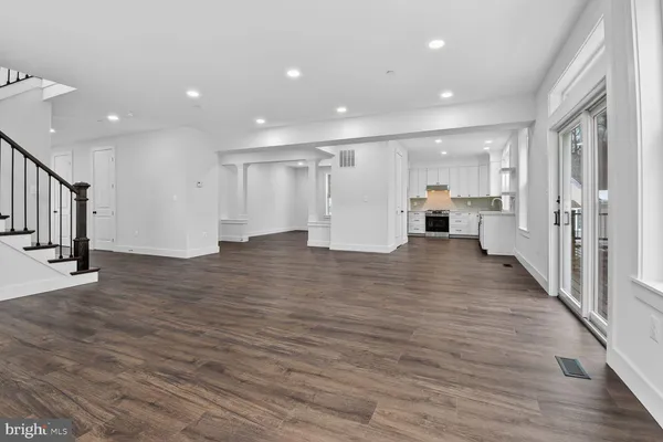 a view of a kitchen with a refrigerator and wooden floor