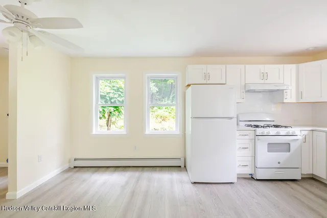 a view of kitchen with wooden floor electronic appliances and window