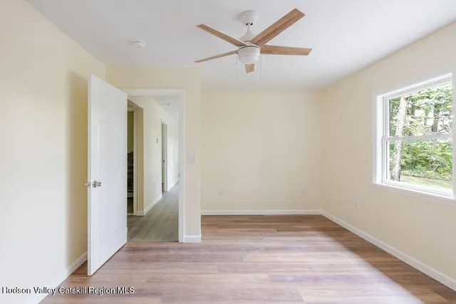 an empty room with wooden floor and windows
