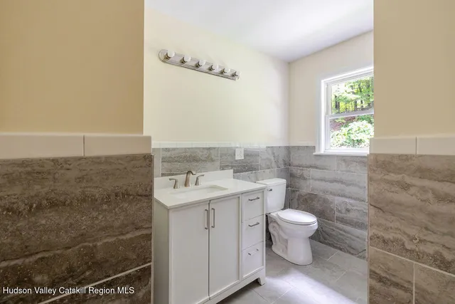 a bathroom with a sink a toilet and a window