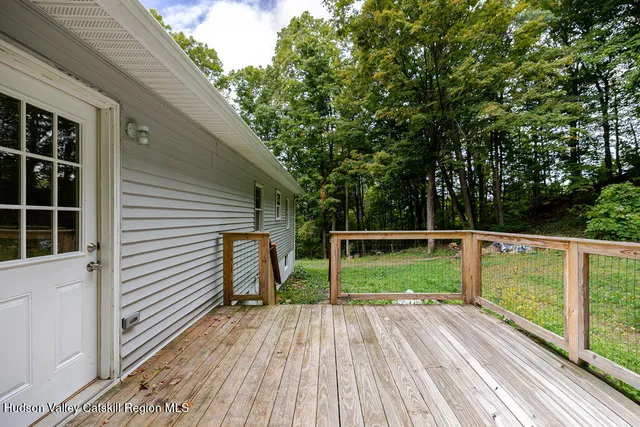 a view of house with deck and wooden floor