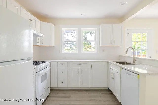 a kitchen with white cabinets and white appliances