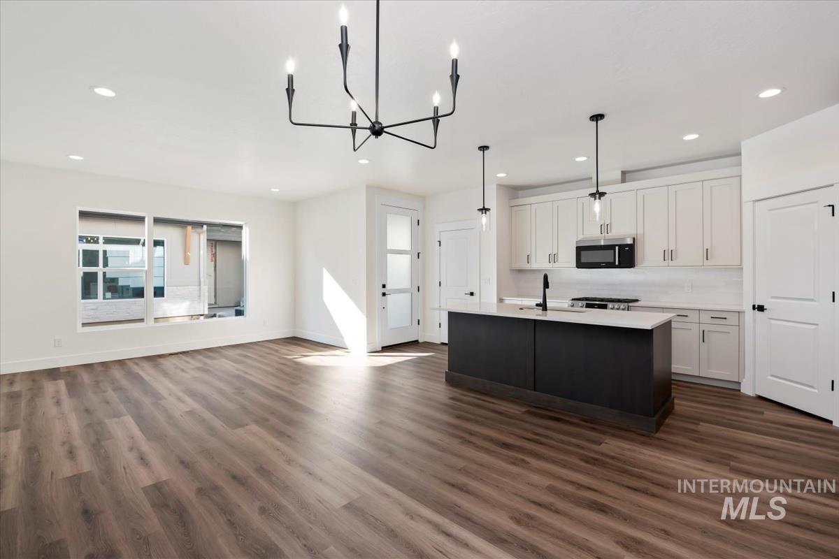 752 South Calhoun Lane Star, ID 83669 - Photo 5 of 45 Open-concept living space featuring wood-finish flooring, recessed lighting, and a contemporary black chandelier