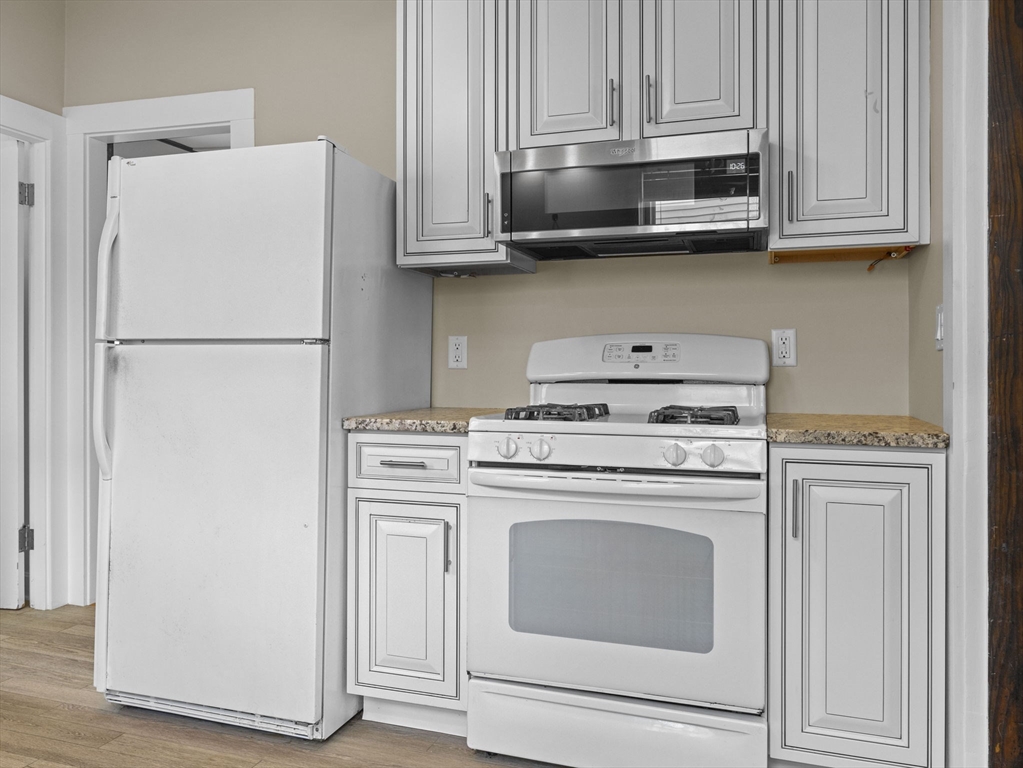 47 Alleyne Street Boston, MA 02132 - Photo 12 of 30 a white refrigerator freezer and a stove sitting inside of a kitchen