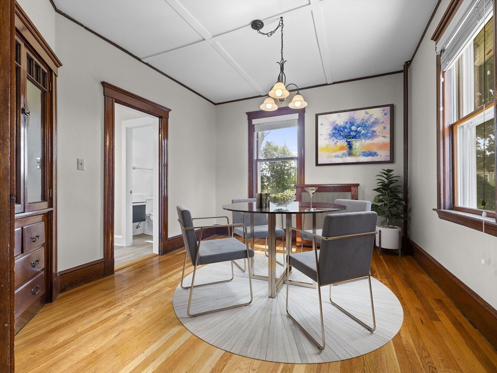 47 Alleyne Street Boston, MA 02132 - Photo 14 of 30 a dining room with wooden floor a chandelier a glass table and chairs