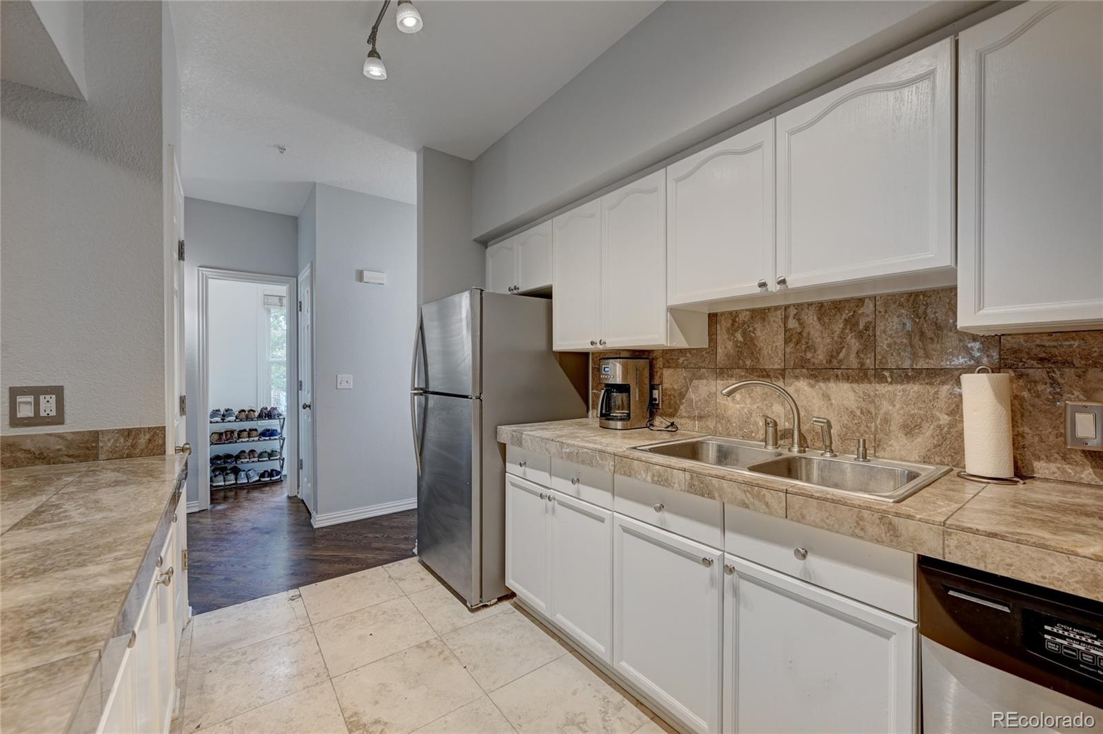 45 Jackson Street, Unit D Denver, CO 80206 - Photo 12 of 26 a kitchen with a sink a refrigerator and cabinets