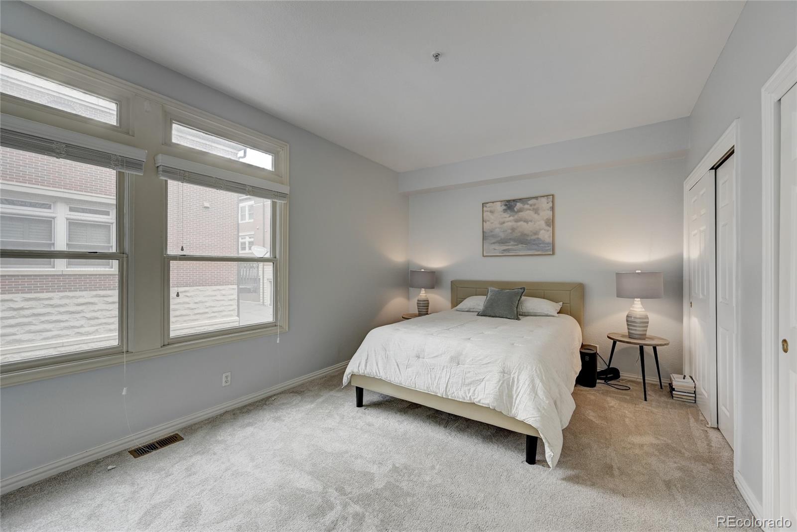 45 Jackson Street, Unit D Denver, CO 80206 - Photo 14 of 26 a bedroom with a bed lamp and a window