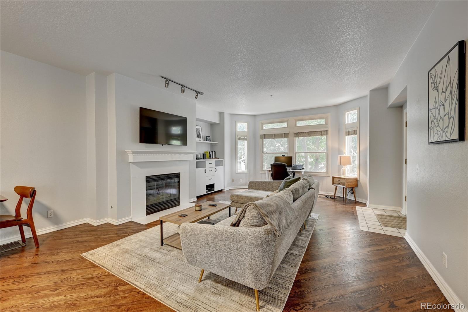 45 Jackson Street, Unit D Denver, CO 80206 - Photo 5 of 26 a living room with furniture a fireplace and a flat screen tv