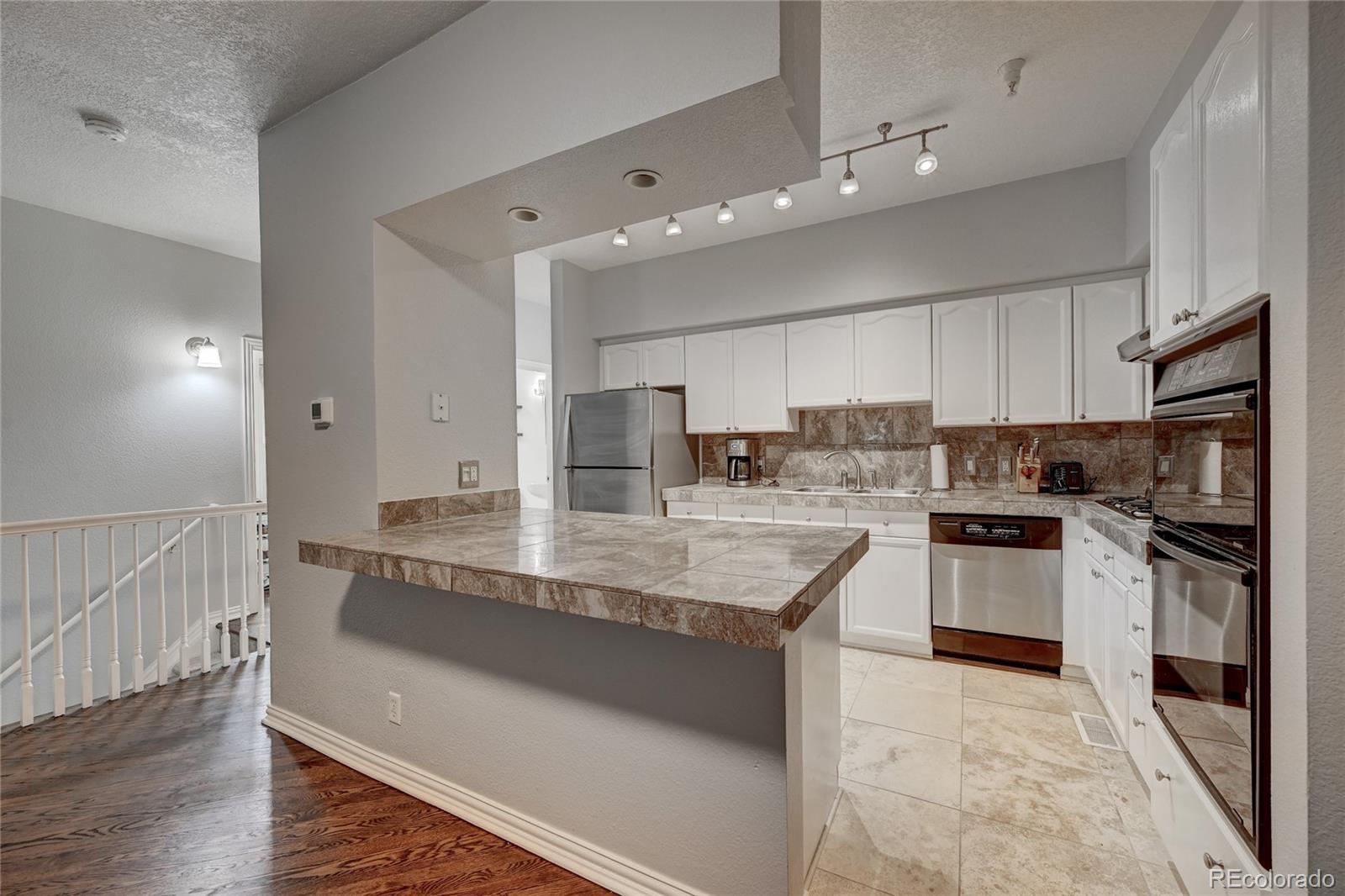 45 Jackson Street, Unit D Denver, CO 80206 - Photo 10 of 26 a large kitchen with granite countertop a large counter top stainless steel appliances and cabinets