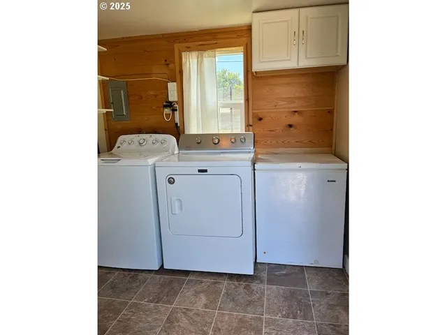a view of a house with a small yard and large trees
