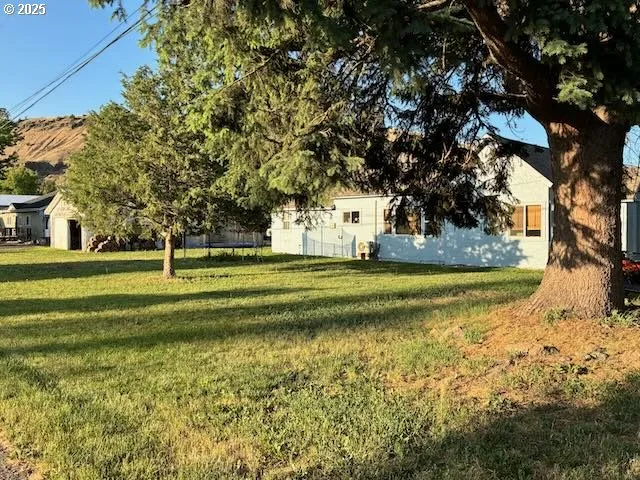 a view of a house with backyard and sitting area