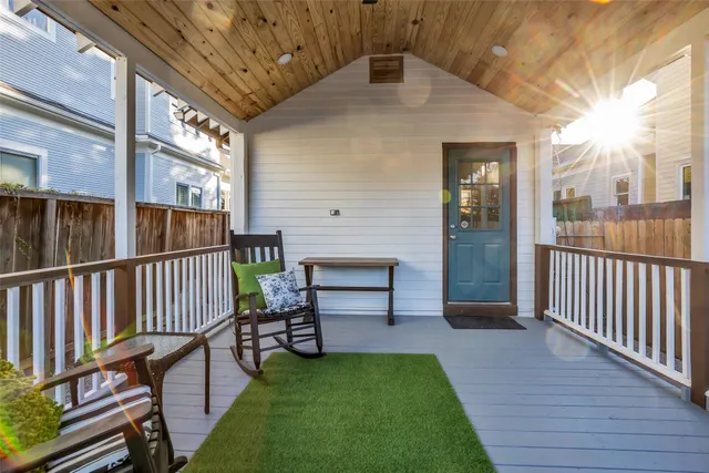 a view of a porch with wooden floor and iron fence