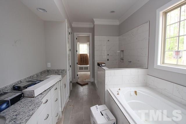 13804 Durant Road Raleigh, NC 27614 - Photo 11 of 25 a bathroom with a granite countertop tub a sink and a large mirror