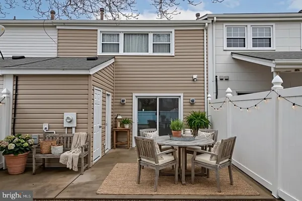 a dining room with furniture and potted plants