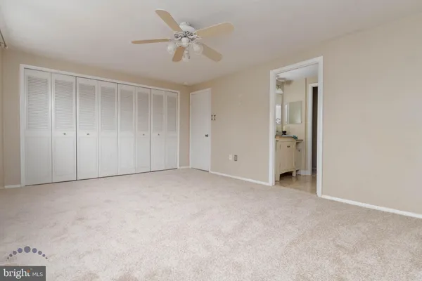 an empty room with a ceiling fan and a window