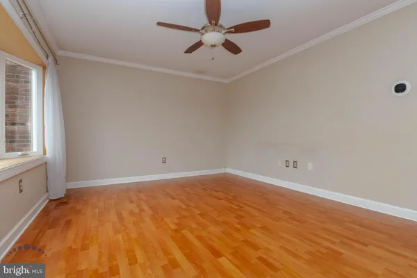 a view of an empty room with a window and wooden floor