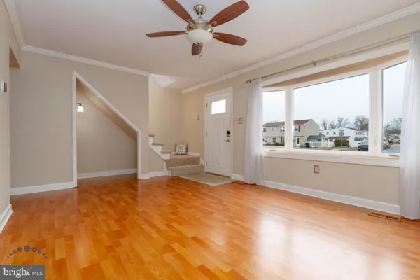 an empty room with a window and a ceiling fan