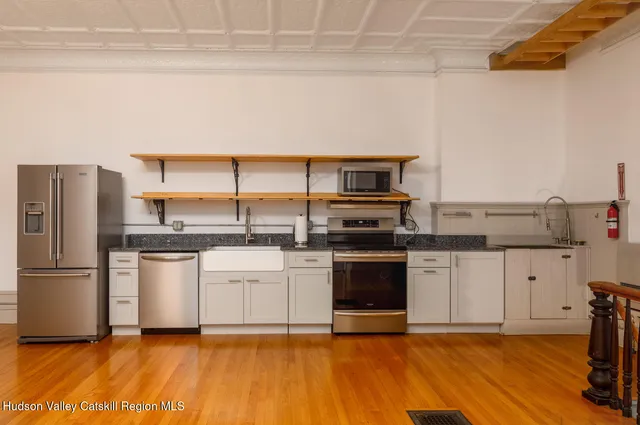 a kitchen with a refrigerator and a stove top oven