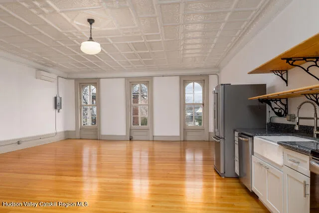 a view of an empty room with window and wooden floor