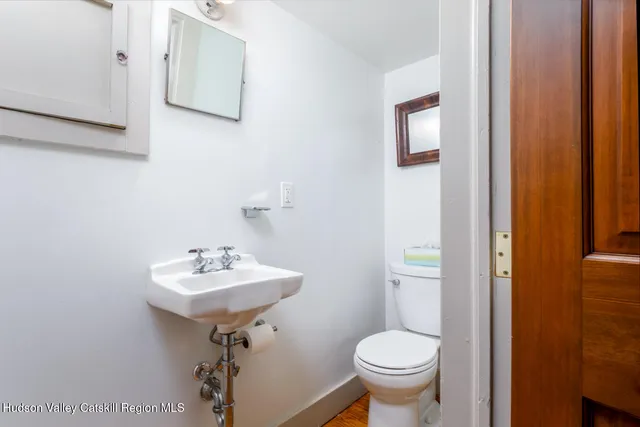 a bathroom with a sink toilet and a mirror