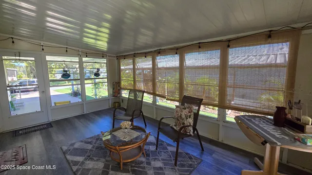 a living room with furniture and a floor to ceiling window